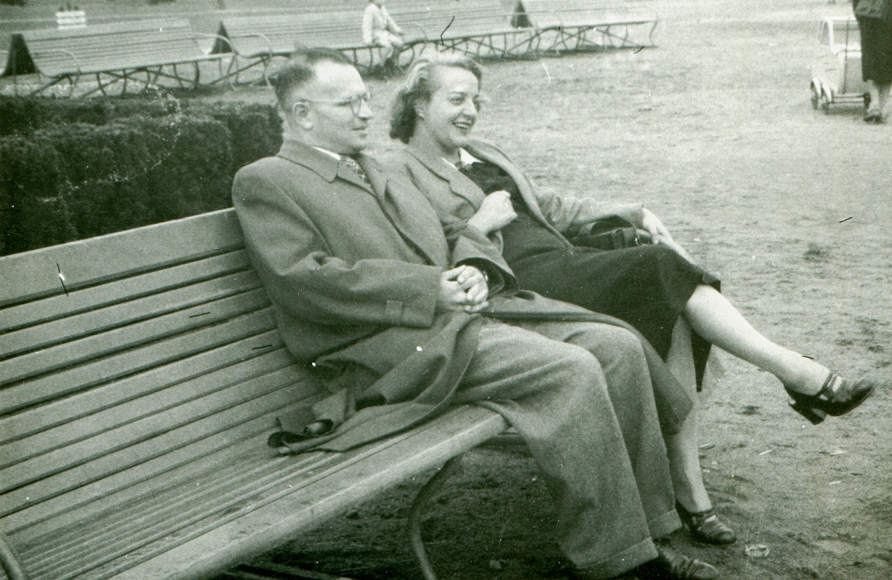 Image of Dateable couple sitting on park bench linking arms.